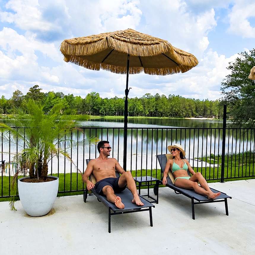 Couple relaxing lakeside under a tiki umbrella at Lake LaCroix RV Resort
