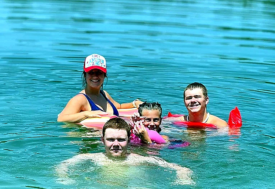 Family cooling off in the lake on a summer afternoon at Lake LaCroix in Bay St. Louis