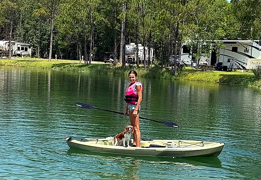 Child and dog kayaking together on the lake at Lake LaCroix in Bay St. Louis