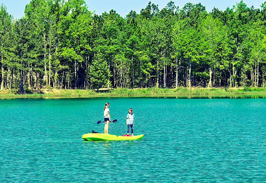 Kayakers paddling the calm bayou lake at Lake LaCroix in Bay St. Louis