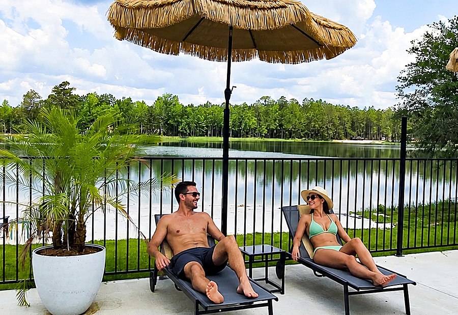 Couple relaxing lakeside under a tiki umbrella at Lake LaCroix in Bay St. Louis