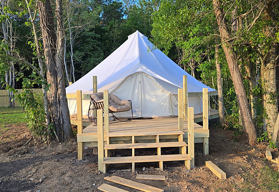 Furnished glamping bell tent on a wooden deck at Lake LaCroix RV Resort in Bay St. Louis