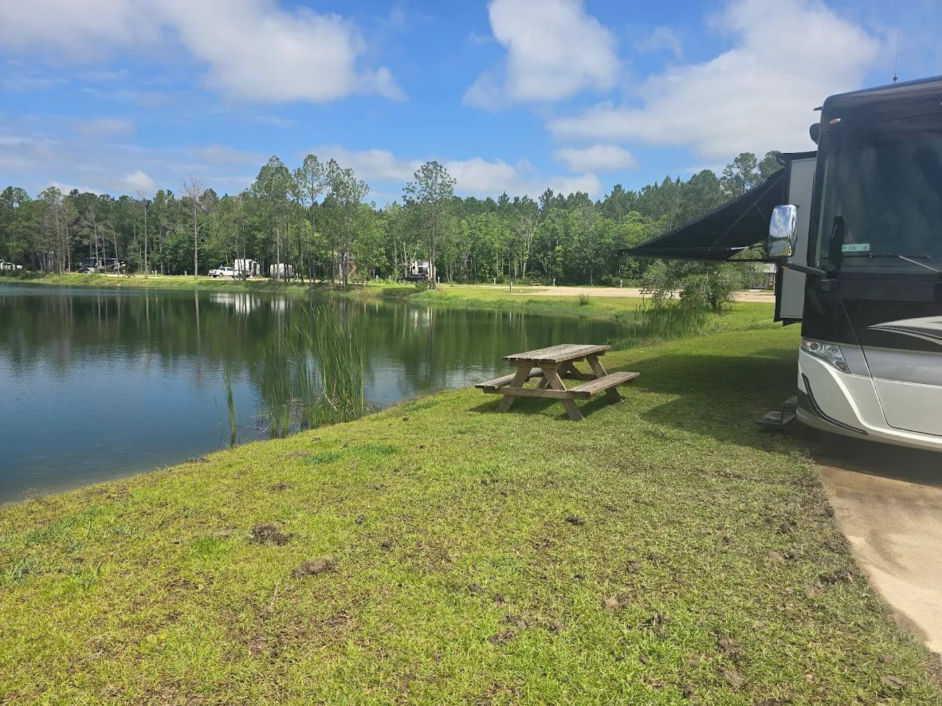 Motorhome parked at a grassy waterfront RV site at Lake LaCroix