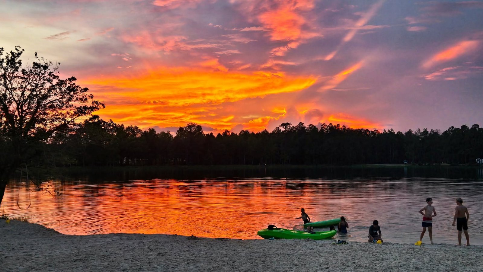 Golden sunset over the lake with guests by the water at Lake LaCroix