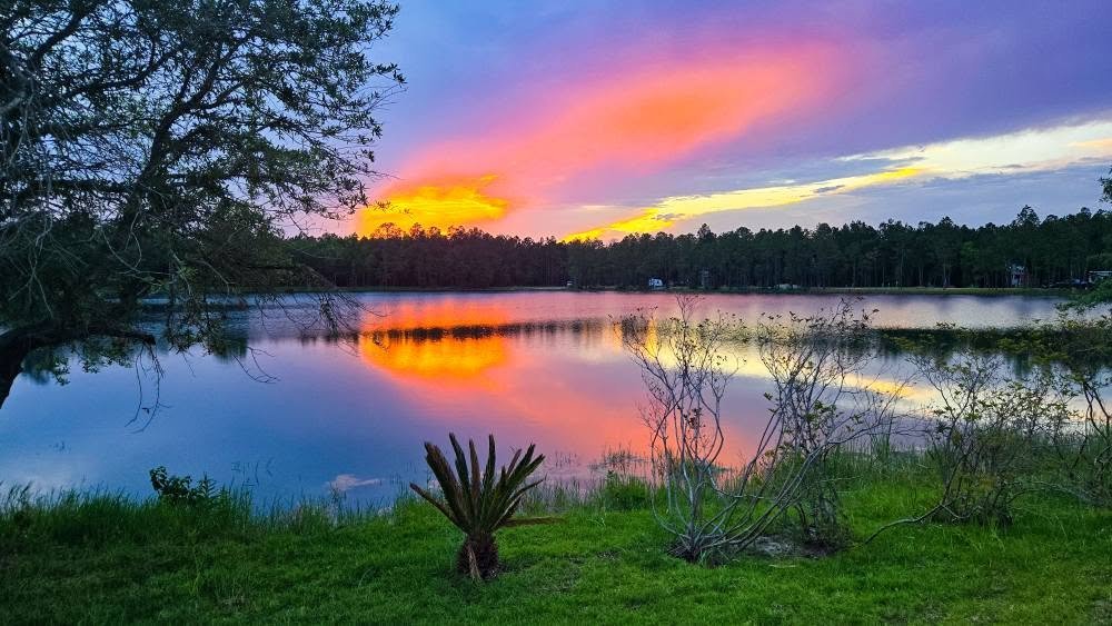 Vivid sunset reflected on the calm lake at Lake LaCroix RV Resort