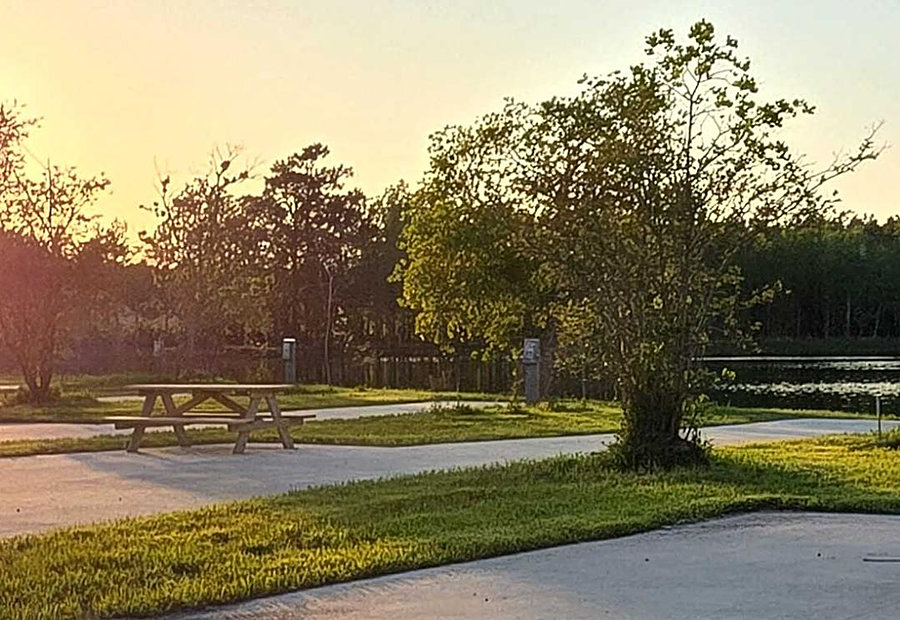 Golden-hour light over lakefront RV sites at Lake LaCroix RV Resort in Bay St. Louis