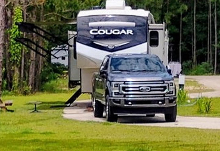 Fifth-wheel RV and truck parked on a spacious concrete pull-through site at Lake LaCroix RV Resort